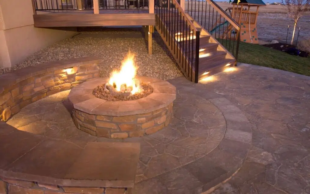 Custom stone fire pit and patio with ambient lighting, perfect for outdoor living in Leander